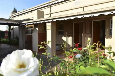 a house with a white flower in front of it at Villa Moria Memoir Cottage in Dullstroom
