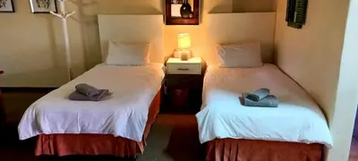 two twin beds sitting next to each other in a room at Villa Moria Memoir Cottage in Dullstroom