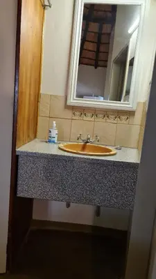 a bathroom counter with a sink and a mirror at Kiaat Bungalows in Hazyview