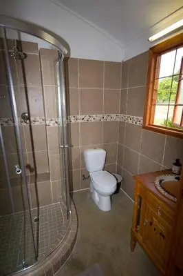 a bathroom with a toilet and a shower and a sink at Kiaat Bungalows in Hazyview