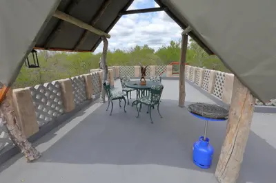 a patio with a table and chairs on a deck at Oasis in the Wild @Marloth in Marloth Park
