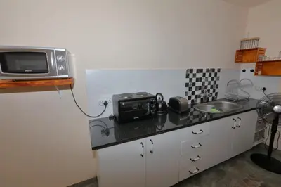 a small kitchen with a microwave and a sink at Oasis in the Wild @Marloth in Marloth Park