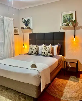 a bedroom with a large bed with pillows on it at Fig Tree Rock 2-bed, 2-bath villa with garden and parking in Nelspruit