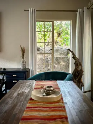 a table with a plate on top of it next to a window at Fig Tree Rock 2-bed, 2-bath villa with garden and parking in Nelspruit