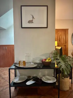 a table with plates and a bowl of fruit on it at Fig Tree Rock 2-bed, 2-bath villa with garden and parking in Nelspruit