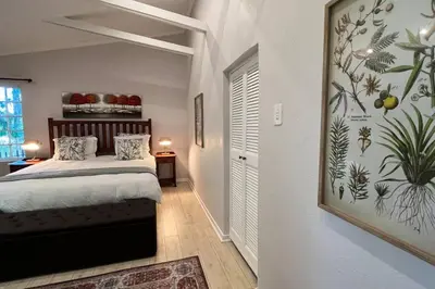a bedroom with a bed and a painting on the wall at Elm Tree House - Dullstroom - holiday home in Dullstroom