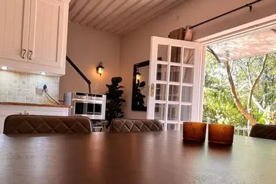 a kitchen with a large wooden table and a large window at Elm Tree House - Dullstroom - holiday home in Dullstroom