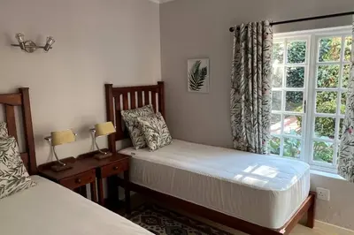 a bedroom with two beds and a window at Elm Tree House - Dullstroom - holiday home in Dullstroom