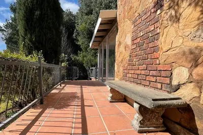 a stone bench sitting next to a brick wall at Elm Tree House - Dullstroom - holiday home in Dullstroom