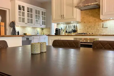 a large kitchen with a table and chairs in it at Elm Tree House - Dullstroom - holiday home in Dullstroom