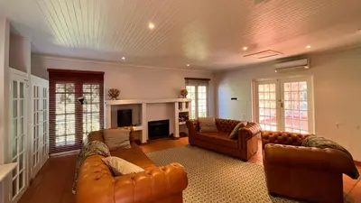 a living room with two leather couches and a fireplace at Elm Tree House - Dullstroom - holiday home in Dullstroom
