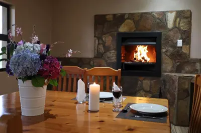 a wooden table with a fireplace in a living room at Uitvlugt Ponds in Dullstroom