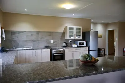 a kitchen with a granite counter top and appliances at Uitvlugt Ponds in Dullstroom
