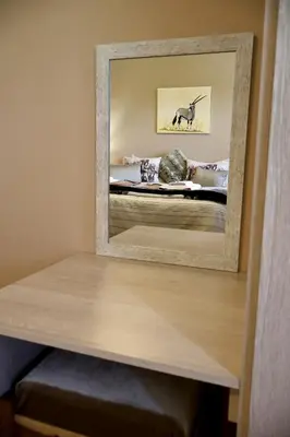 a mirror on a table with a bed in a room at Uitvlugt Ponds in Dullstroom