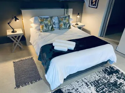 a bedroom with a large bed with two towels on it at 46 on Allcock Guest Apartment & Luxury Room in Pretoria