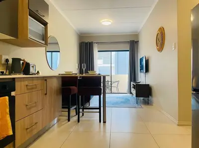 a kitchen with a counter and a table with chairs at Mikeys Place on Lever with Fibre Uncapped WiFi in Midrand