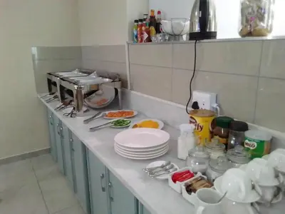 a kitchen counter with plates and dishes on it at Benoni N12 Hotel in Benoni