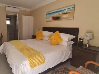 a bedroom with a large bed with yellow pillows at Benoni N12 Hotel in Benoni