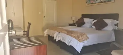 a bedroom with a bed with white sheets and pillows at Benoni N12 Hotel in Benoni
