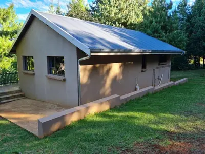 a small white building with a blue roof at Ukutula Resort in Dullstroom