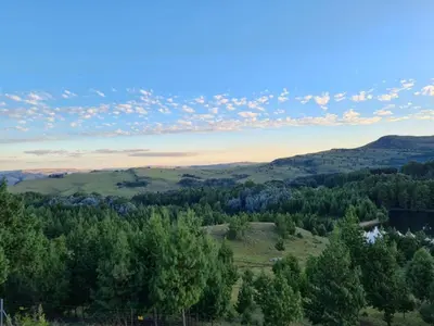 a view of a valley with trees and mountains at Ukutula Resort in Dullstroom