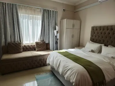 a bedroom with a large bed and a window at Bela Valley Guest House in Bela-Bela