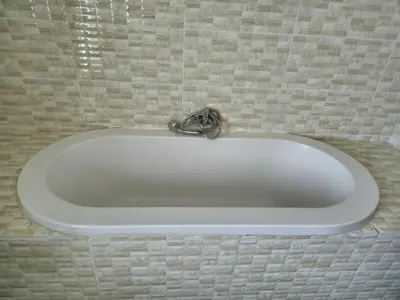 a white bath tub in a tiled wall at Bela Valley Guest House in Bela-Bela