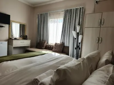 a bedroom with a large white bed and a window at Bela Valley Guest House in Bela-Bela