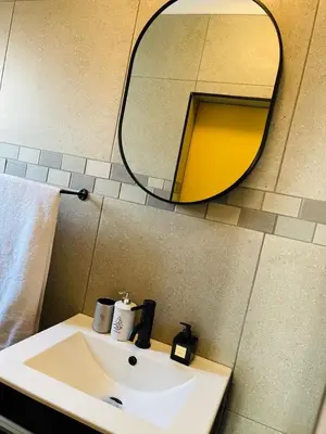 a bathroom with a sink and a mirror at Luxuries Penthouse in Nelspruit