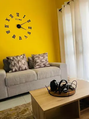 a living room with a couch and a clock on the wall at Luxuries Penthouse in Nelspruit