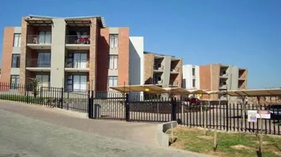 a building with a fence in front of it at Luxuries Penthouse in Nelspruit