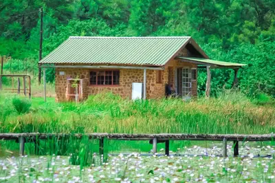 a small house in the middle of a field at Harnham Mountain Lodge in Louis Trichardt