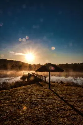 an umbrella in a field with the sun in the sky at Harnham Mountain Lodge in Louis Trichardt