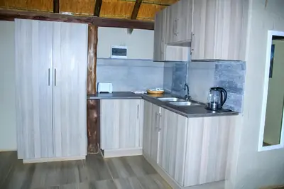a kitchen with white cabinets and a sink at Harnham Mountain Lodge in Louis Trichardt
