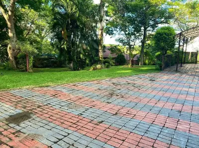 a brick driveway in a yard with trees and grass at Serenity Garden Place in Hazyview