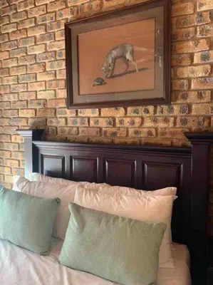 a painting of a dog on the wall above a bed at Serenity Garden Place in Hazyview