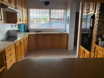 a kitchen with wooden cabinets and a large window at Serenity Garden Place in Hazyview