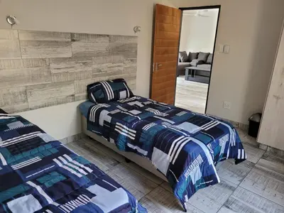 a bedroom with two beds and a mirror at Cats Corner in Marloth Park