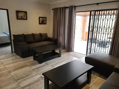 a living room with a couch and a coffee table at Cats Corner in Marloth Park