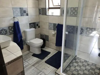 a bathroom with a toilet and a shower at Cats Corner in Marloth Park