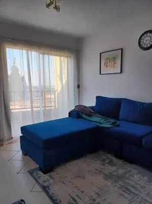 a blue couch in a living room with a window at The cozy 1 bedroom apartment in Midrand
