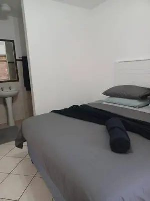 a bedroom with a bed and a sink in a room at The cozy 1 bedroom apartment in Midrand