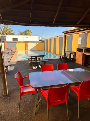 a patio with tables and chairs and a pool at Platinum Guesthouse Kempton park in Kempton Park