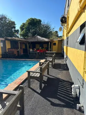 a group of benches next to a swimming pool at Platinum Guesthouse Kempton park in Kempton Park