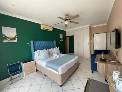 a bedroom with a bed and a green wall at The Yacht House in Hartbeespoort