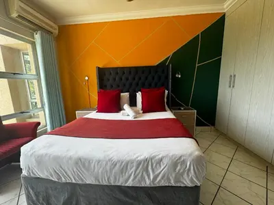 a bedroom with a large bed with red pillows at The Yacht House in Hartbeespoort