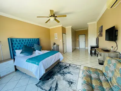 a bedroom with a bed and a ceiling fan at The Yacht House in Hartbeespoort