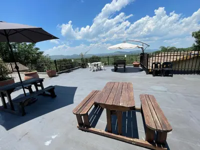 two picnic tables and an umbrella on a patio at The Yacht House in Hartbeespoort