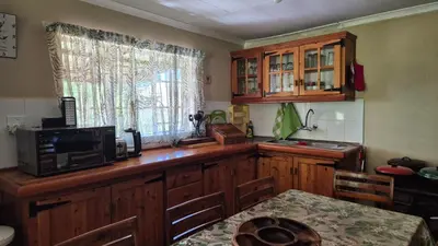 a kitchen with a counter with a microwave and a table at Apple Blossom Cottage in Dullstroom