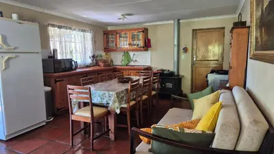 a kitchen with a table and a kitchen with a couch at Apple Blossom Cottage in Dullstroom